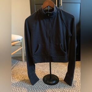 SKIMS Outdoor track jacket, specifically a cropped full-zip model in black